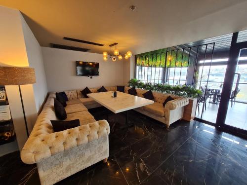 una sala de estar con sofás y una mesa en una habitación en Air Boss Istanbul Airport and Fair Hotel en Estambul