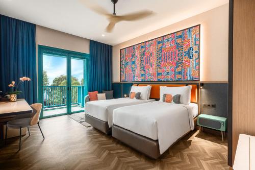 a bedroom with a large bed and a desk and a window at Resorts World Sentosa - Hotel Ora in Singapore