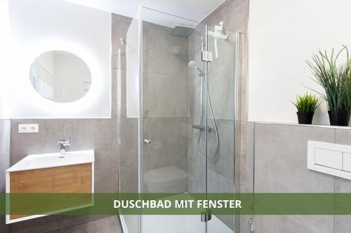 ein Bad mit einer Dusche und einem Waschbecken in der Unterkunft Die Fichtelsuite 1-6 Pers Ferienwohnung nahe Ochsenkopf Süd 800m in Fleckl in Warmensteinach