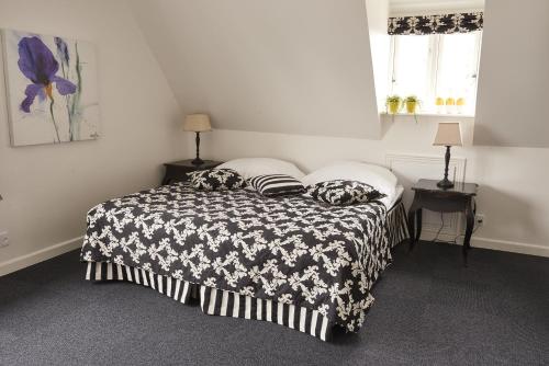 a bedroom with a bed with a black and white blanket at Hotel Faaborg Fjord in Fåborg