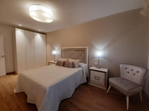 - une chambre avec un grand lit et une chaise dans l'établissement Aires De Míguez, à Jove