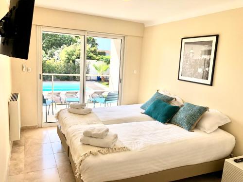 1 dormitorio con 2 camas y ventana grande en Villa Montfleuri, vieille ville à pieds, vue mer, piscine, 8 pers, en Sainte-Maxime