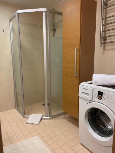 a washing machine in a bathroom with a shower at City Center Tartu mnt - FREE Parking in Tallinn
