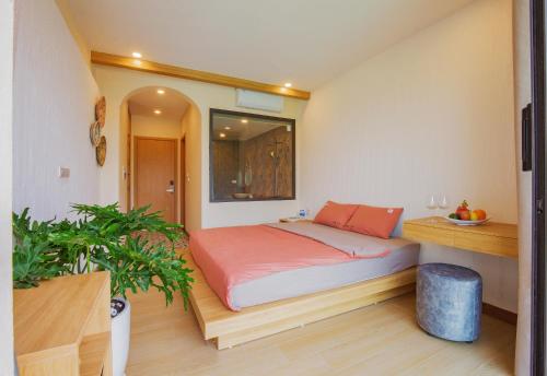 a bedroom with a bed and a potted plant at Melody Retreat - Venuestay in Hòa Bình