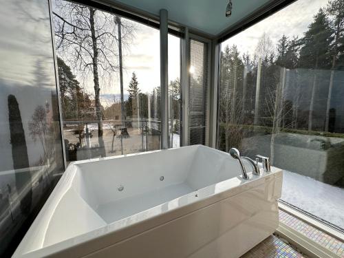 a bath tub in a bathroom with a large window at Merirahu private luxury villa in Tallinn