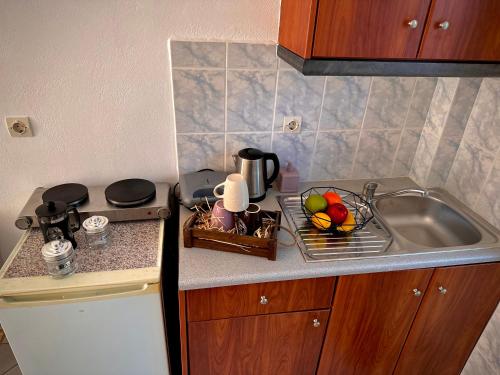 a kitchen counter with a sink and a sink at Katerina Apartments in Lefkimmi