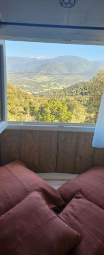 a bed in a room with a large window at U Casedu di ghjuvani in Granace