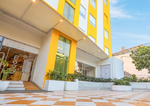 ein gelbes und weißes Gebäude mit Fliesenboden in der Unterkunft Bloom Hotel - Jalandhar in Jalandhar