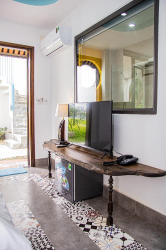 a mirror on a wall with a wooden table at La Y Riverview in Hue