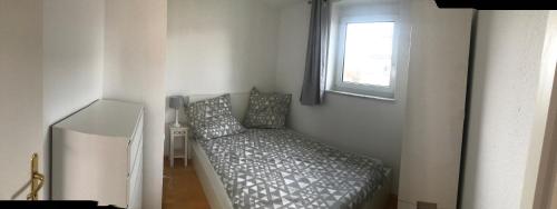 - une petite chambre avec un lit et une fenêtre dans l'établissement Cozy Appartment with Balcony, à Friedrichshafen