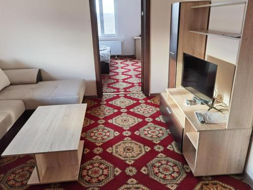 een woonkamer met een bank en een flatscreen-tv bij Винарна-Славовица in Kalugerovo