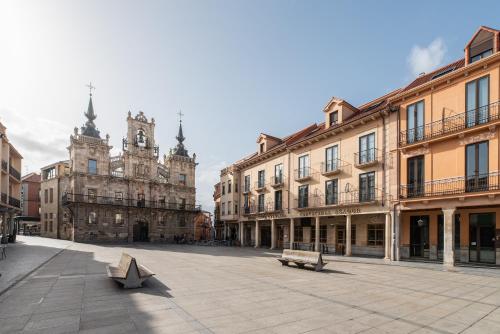 ein Stadtplatz mit Gebäuden und einem Uhrturm in der Unterkunft Exe Astur Plaza in Astorga