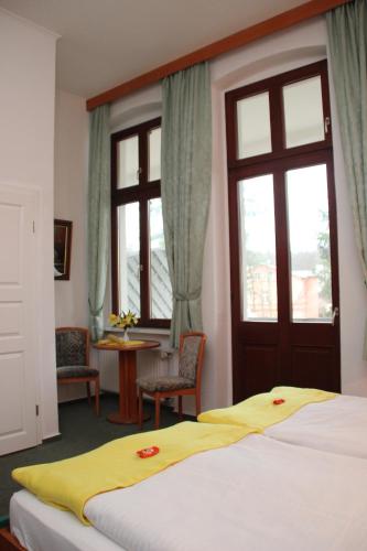 a bedroom with a bed with a yellow blanket on it at Haus Alexander in Heringsdorf