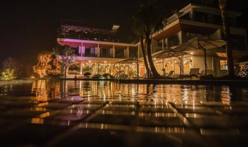 a pool of water in front of a building at night at Melody Retreat - Venuestay in Hòa Bình