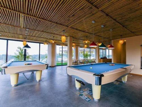 two pool tables in a large room with windows at Melody Retreat - Venuestay in Hòa Bình