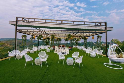 a group of white chairs and tables on the grass at Melody Retreat - Venuestay in Hòa Bình