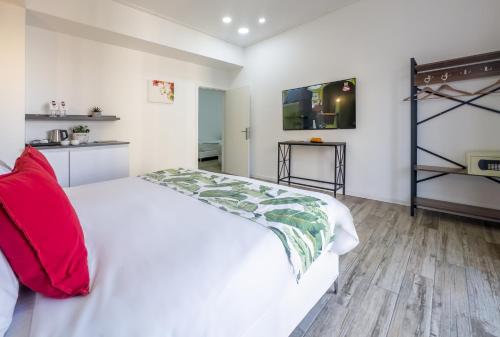 a white bed with red pillows in a bedroom at Paamonim Hotel Jerusalem in Jerusalem