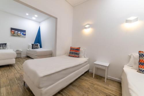 a white room with a bed and a couch at Paamonim Hotel Jerusalem in Jerusalem