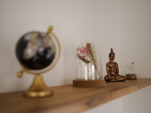 a small statue sitting on a shelf next to a clock at Domus Optima - Cozy Retreat in Vienna in Vienna