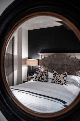 a bedroom with a large bed with a mirror at The Bloomsbury Hotel in London