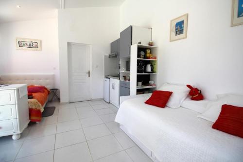 Habitación blanca con 2 camas y cocina en Les carpes a limoges en Limoges
