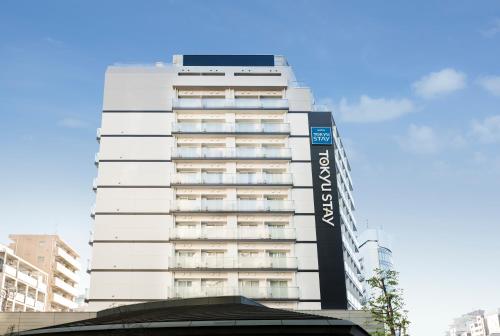 un edificio blanco alto con un letrero. en Tokyu Stay Shibuya Shin-Minamiguchi, en Tokio