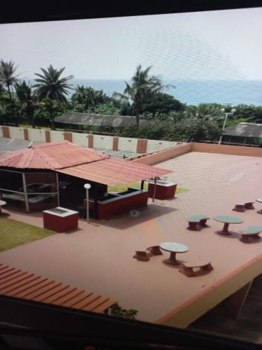 a view of a patio with tables on a roof at Amanzimtoti Beachfront Holiday Apartment , Flat No 23, Ezulweni in Durban
