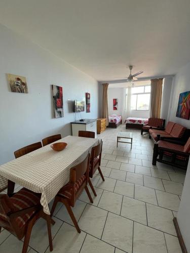 Amanzimtoti Beachfront Holiday Apartment , Flat No 23, Ezulweni في ديربان: غرفة مع طاولة وكراسي وغرفة معيشة