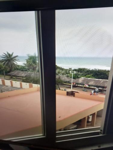 a view of the beach from a window at Amanzimtoti Beachfront Holiday Apartment , Flat No 23, Ezulweni in Durban