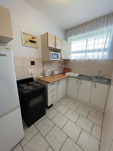 a small kitchen with a stove and a sink at Amanzimtoti Beachfront Holiday Apartment , Flat No 23, Ezulweni in Durban