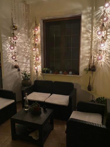 sala de estar con sofá y ventana con luces en Il Focolare Casa Vacanza, en Torchiarolo
