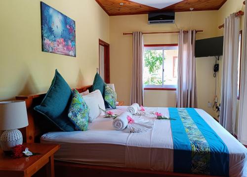 a bedroom with a bed with two dolls on it at Badamier Self-Catering in La Digue