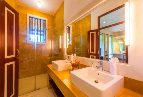 a bathroom with a sink and a shower and a mirror at Zylan Colombo in Colombo
