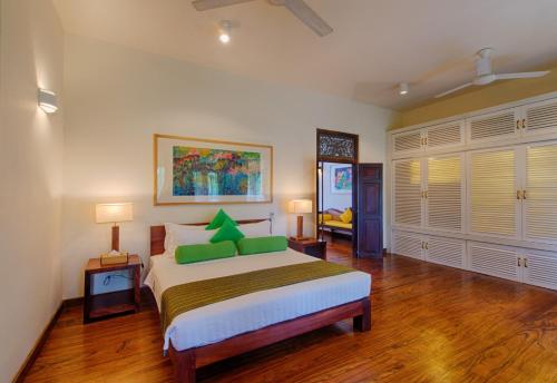 a bedroom with a large bed with green pillows at Zylan Colombo in Colombo