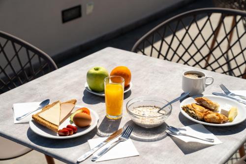 a table with plates of food and a glass of orange juice at Dunlin Hotel in Athens