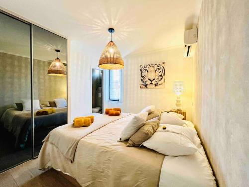 une chambre avec un grand lit blanc avec des oreillers dans l'établissement Cannes centre , magnifique , 5 min palais, à Cannes