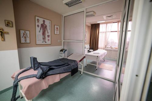 a hospital room with a bed and a mirror at Hotel Secret Garden in Baia-Sprie