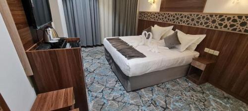 فندق بياك أوتيل الروضة في مكة المكرمة: غرفة فندقية عليها سرير بجعتين
