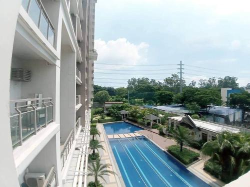 an overhead view of a swimming pool next to a building at Queen BR+Mat, Olympic Pool / Near NAIA T3 in Manila