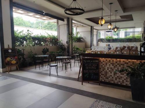 a restaurant with tables and chairs in a room at Queen BR+Mat, Olympic Pool / Near NAIA T3 in Manila