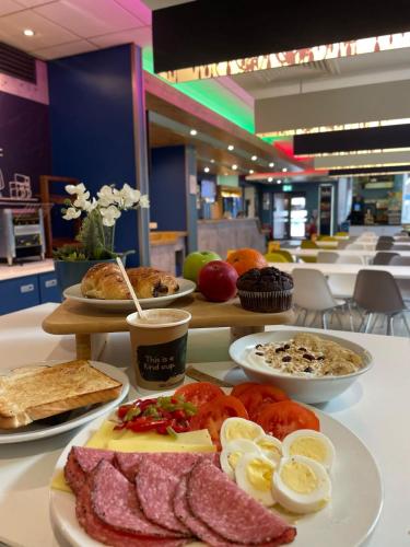 a table with plates of food on a table at ibis budget Belfast City Centre in Belfast
