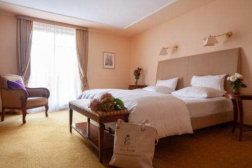 a hotel room with a large bed and a chair at Hotel Erbprinz - Gourmet & Spa in Ettlingen