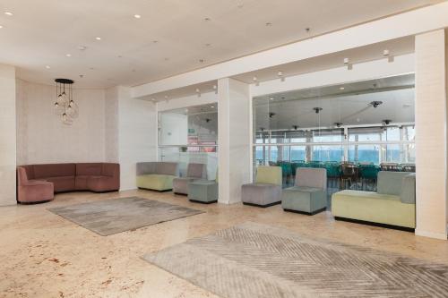 a lobby with chairs and tables in a building at Residence Beach Hotel in Netanya