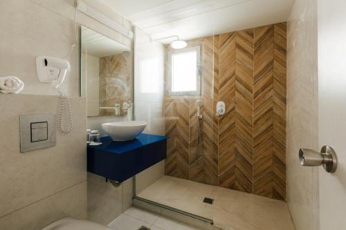 a bathroom with a sink and a toilet and a mirror at Residence Beach Hotel in Netanya