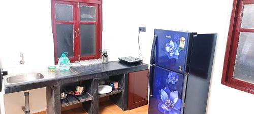 uma cozinha com um lavatório e um frigorífico em Lairai's Happy Home em Candolim