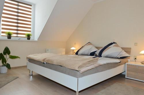 ein Schlafzimmer mit einem großen Bett im Dachgeschoss in der Unterkunft AMF Ferienwohnungen historischer Soutyhof in Saarlouis