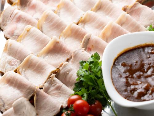 a plate of food with ham and a bowl of dipping sauce at Spa and Resort Hotel Solage Oita Hiji Beppuwan in Beppu
