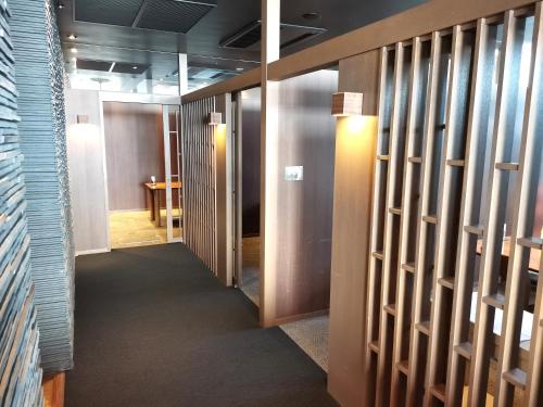 a hallway with doors and a room with a table at Spa and Resort Hotel Solage Oita Hiji Beppuwan in Beppu