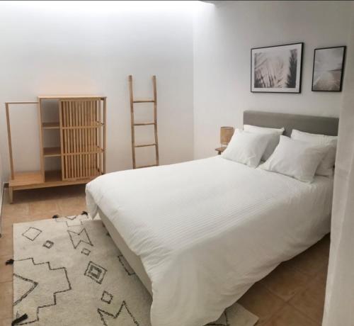 a bedroom with a large white bed and a ladder at Accommodation in Sesimbra - Two Double Bedroom in Sesimbra