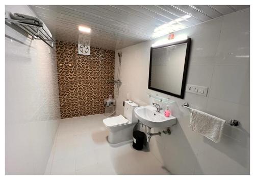 a bathroom with a white toilet and a sink at The Cocoon Camps & nature Resorts in Nainital